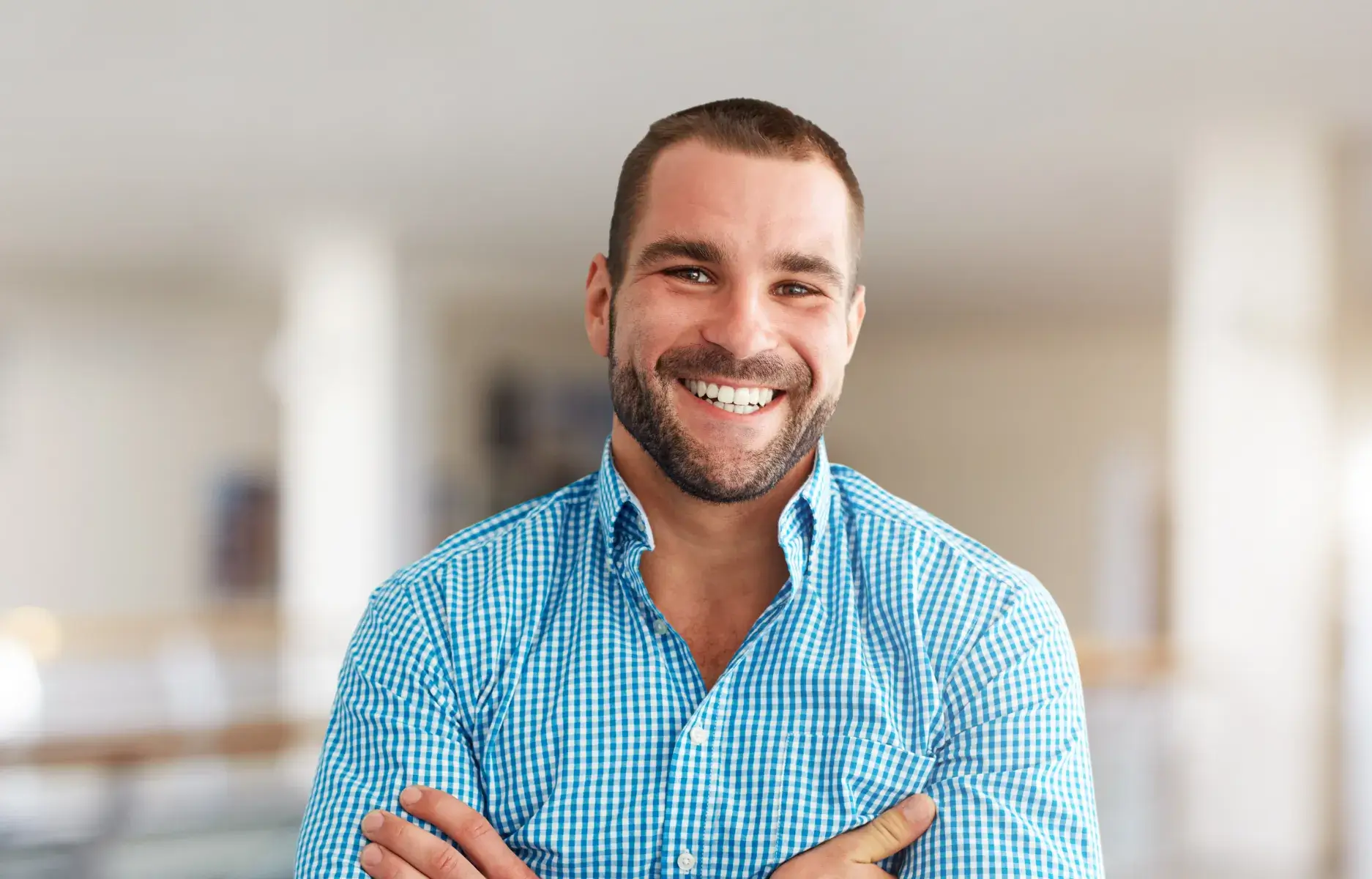 a smiling man with his arms crossed