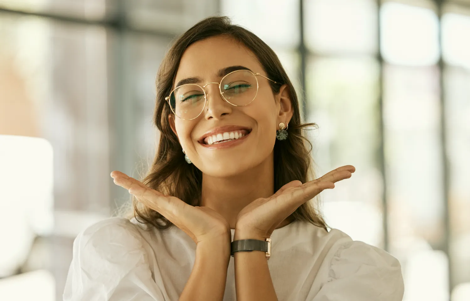 a woman wearing glasses making a gesture with her hands