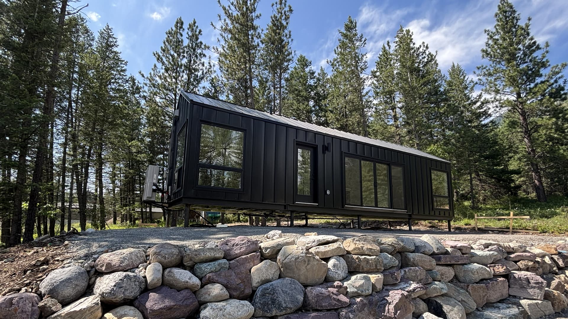 Wide angle view of a Mod Series model in a woodland setting, structured on top of gravel.