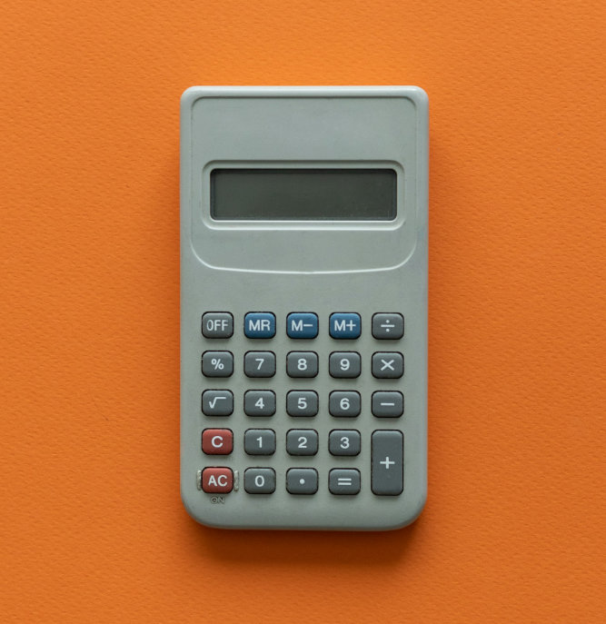 Silver calculator on yellow desk