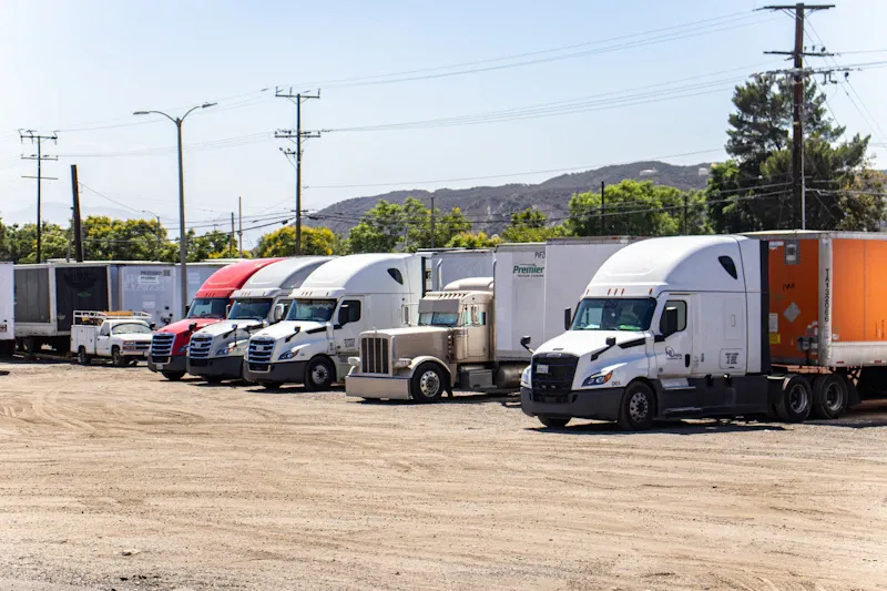 Fleet service for heavy-duty trucks, showing multiple semi tractors and trailers lined up in a commercial truck yard.