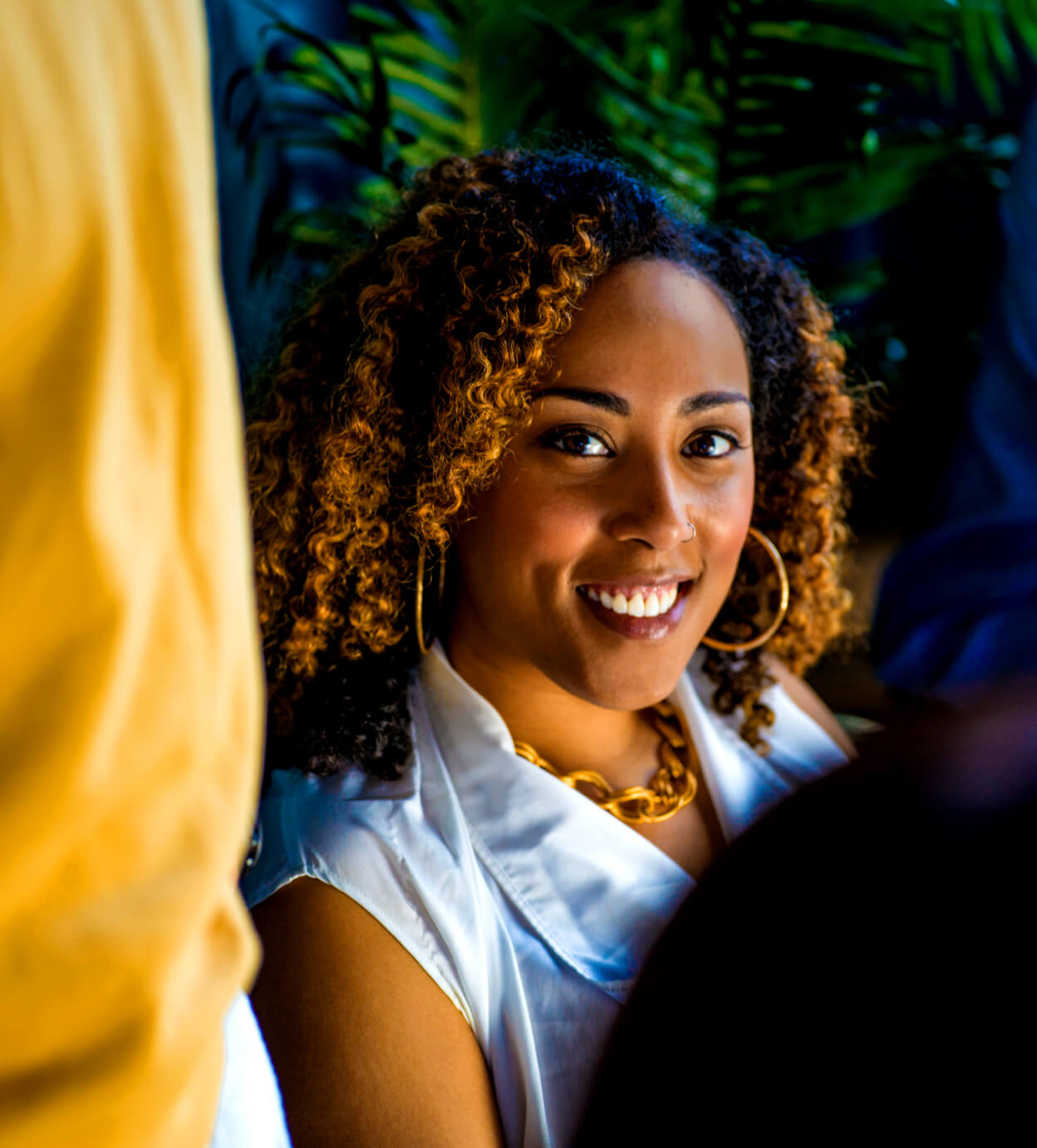 A lady with tinted hair smiling at rhe camera
