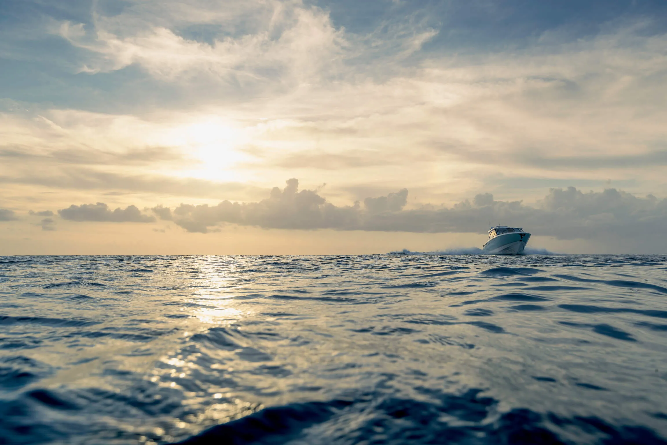 A couple dangles their feet off of the bow of the boat while hugging each other