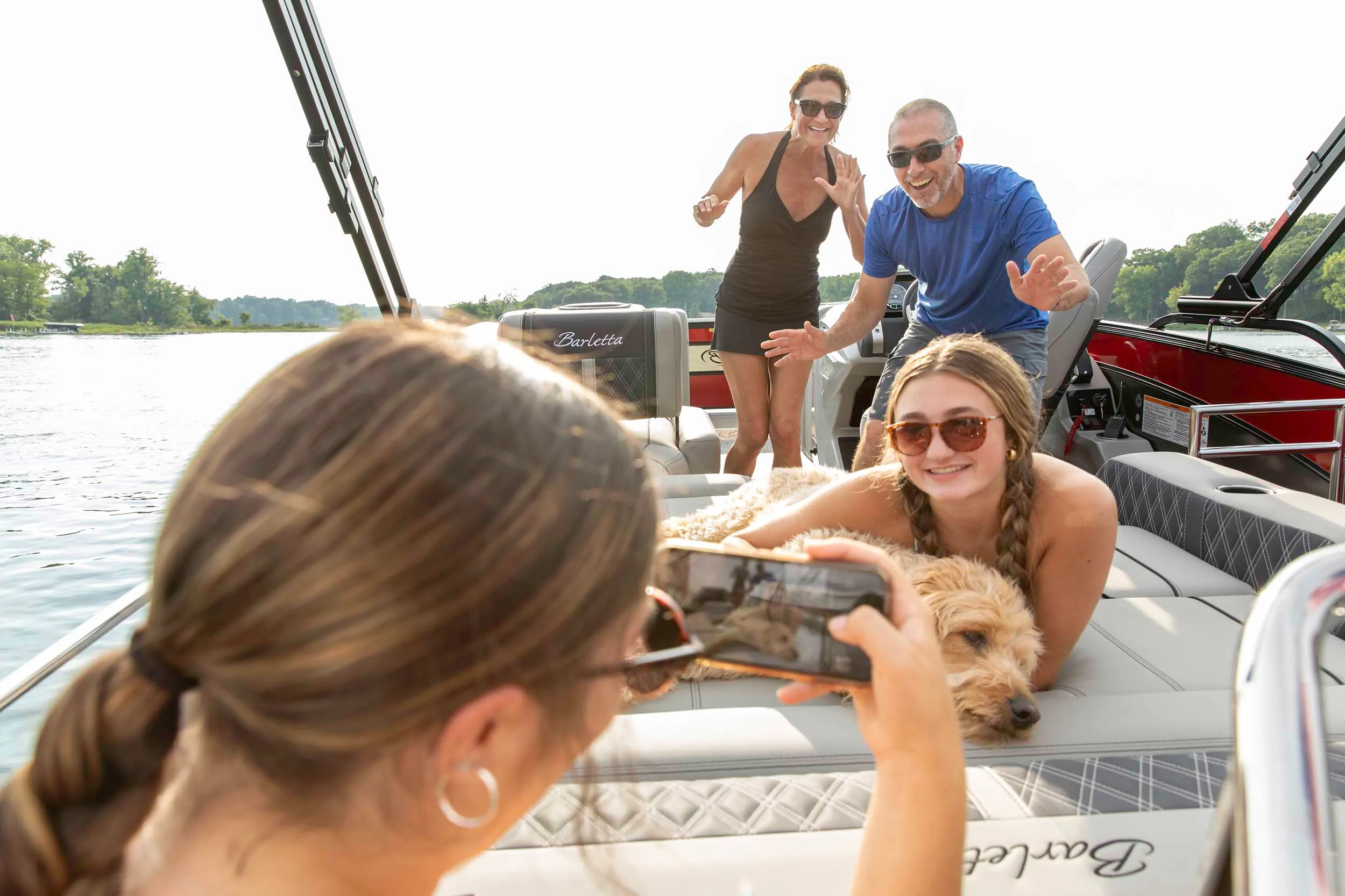 A couple dangles their feet off of the bow of the boat while hugging each other