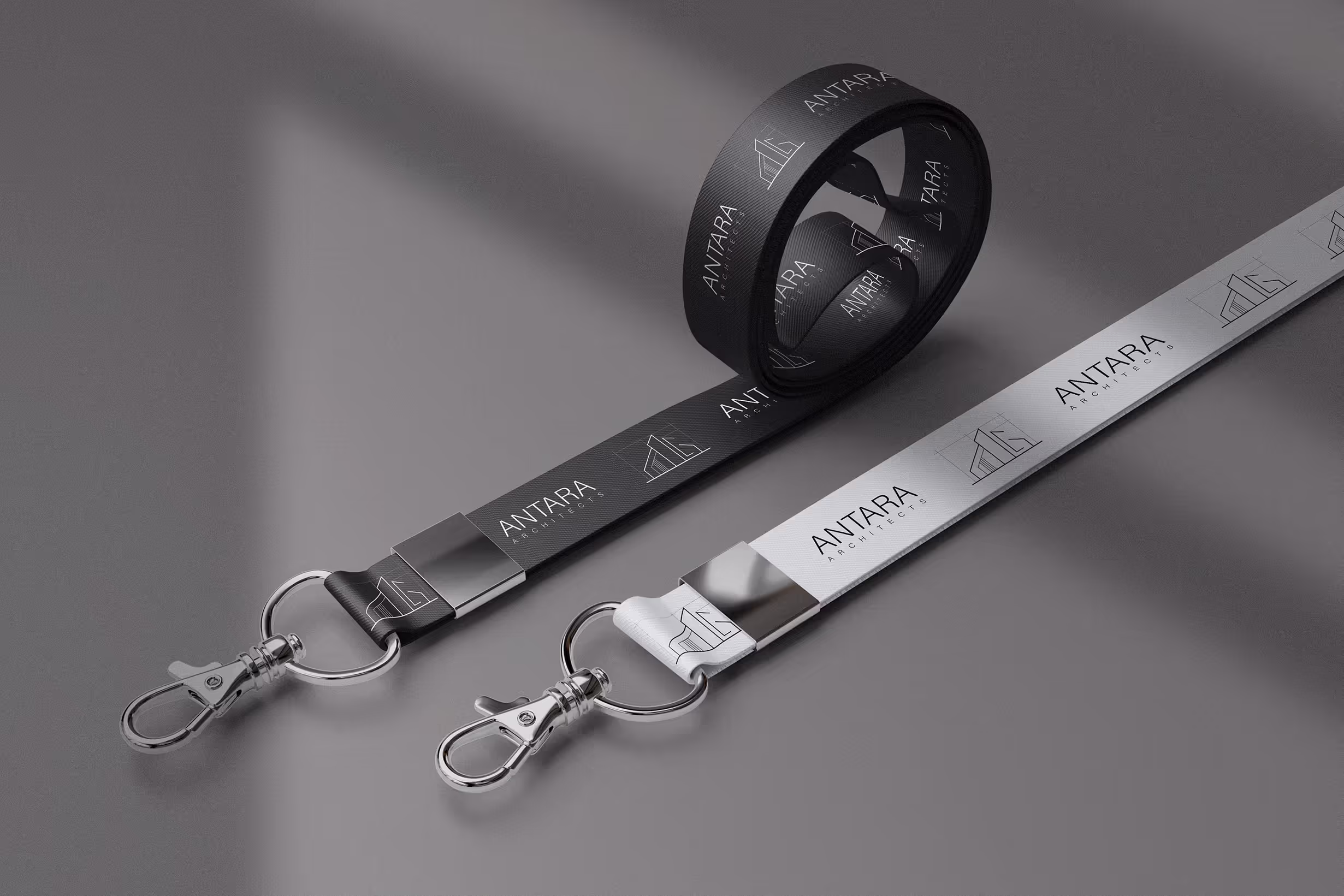 Product mock up of lanyard. On it is antara wordmark and icon logo. in grey and almost white.