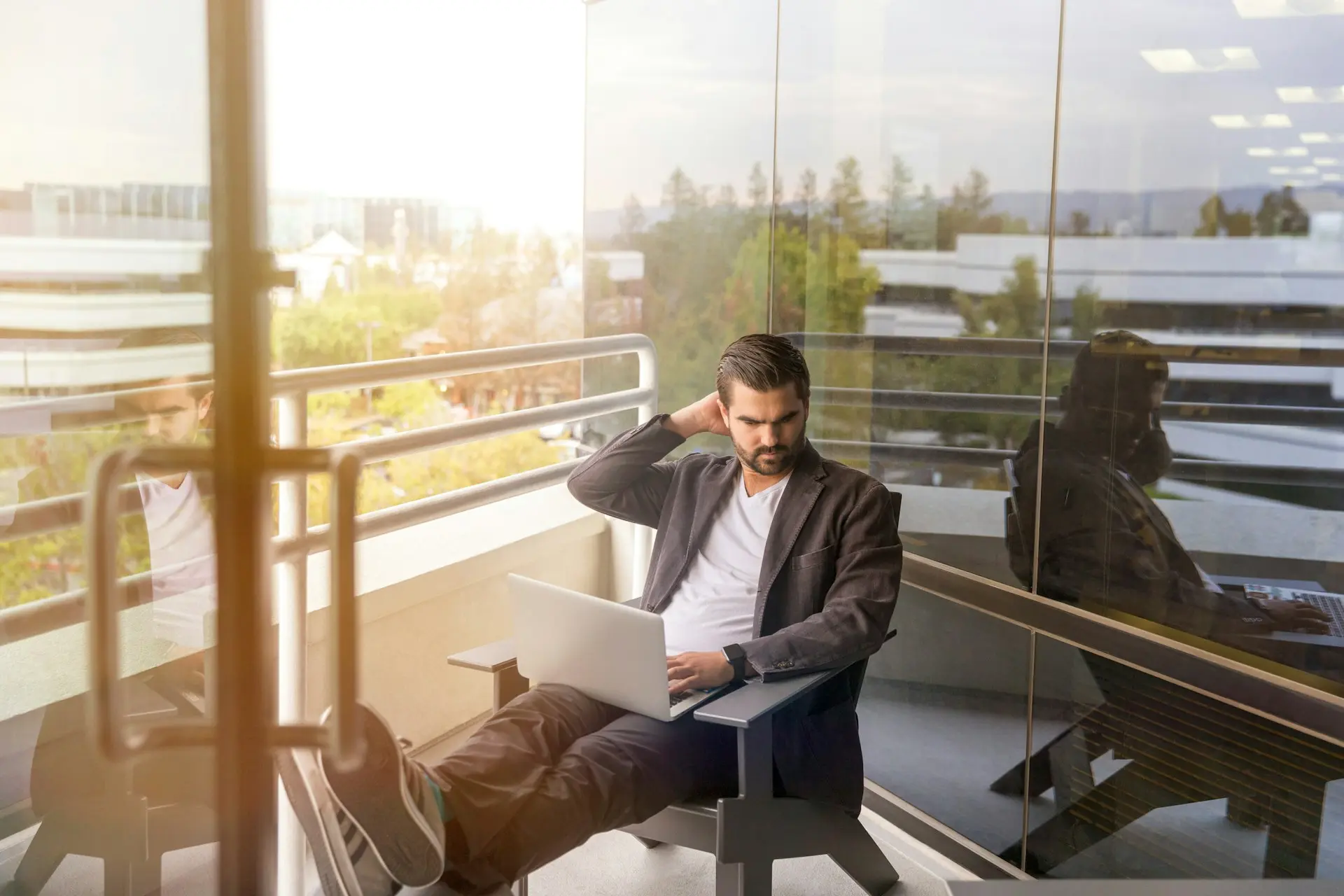 Pensive businessman working with laptop on the office terrace