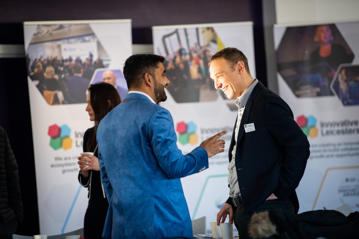 Two men talking to each other at a business event