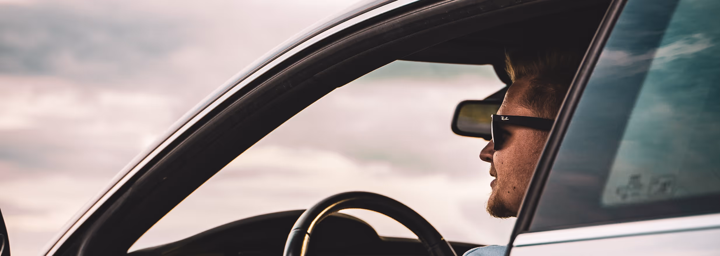 individual sitting in their car looking off in the distance
