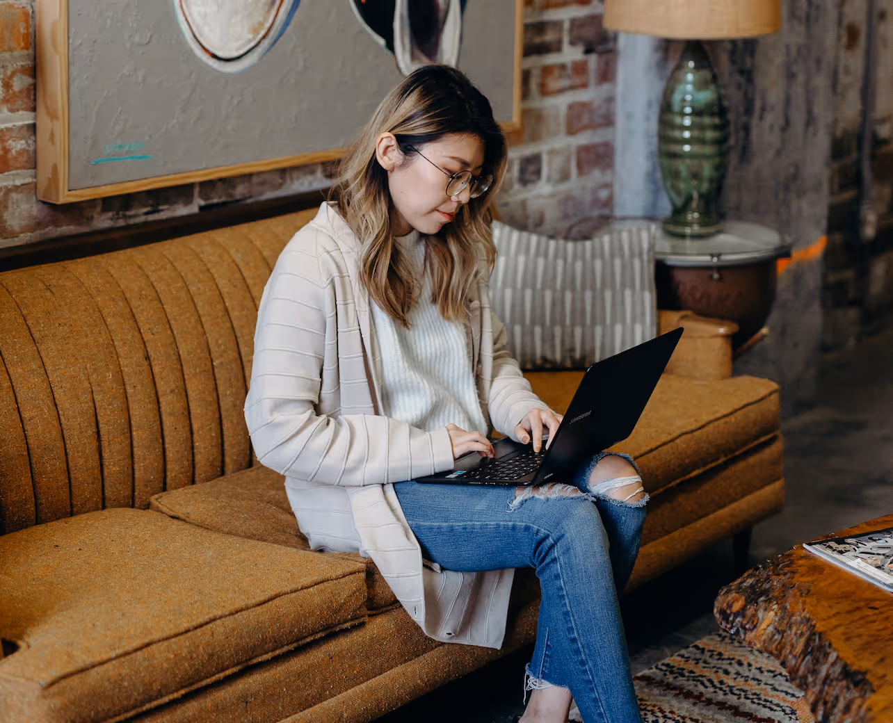woman sitting on the couch looking at her laptop