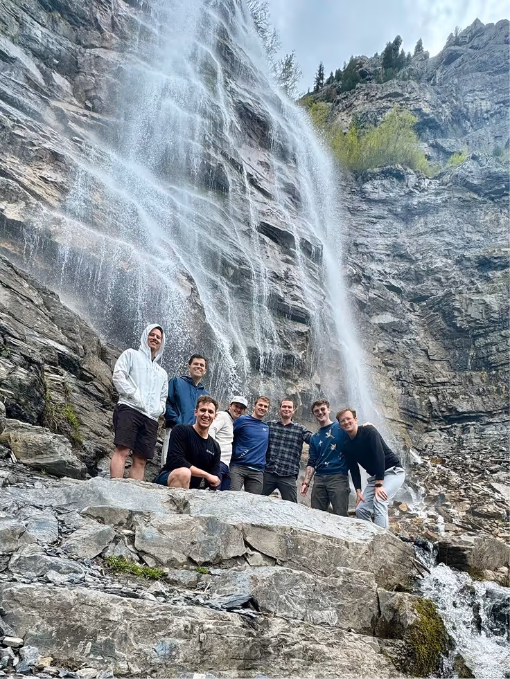 Halda team visiting a scenic waterfall in a natural setting