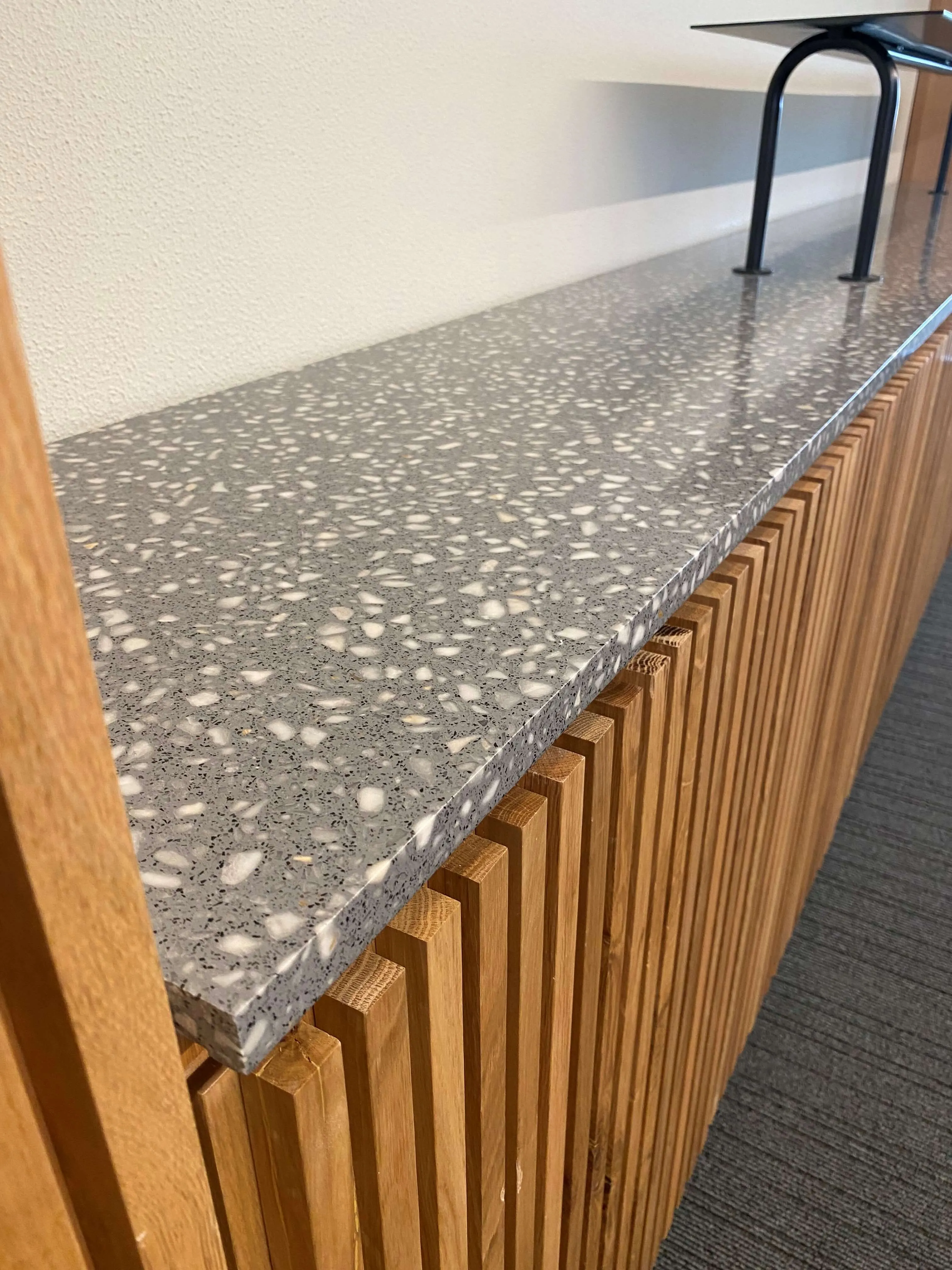 tampo de móvel para escritório em solução de terrazzo na cor cinzento com agregados grandes na cor branco / furniture counter for an office in a grey and white terrazzo solution.
