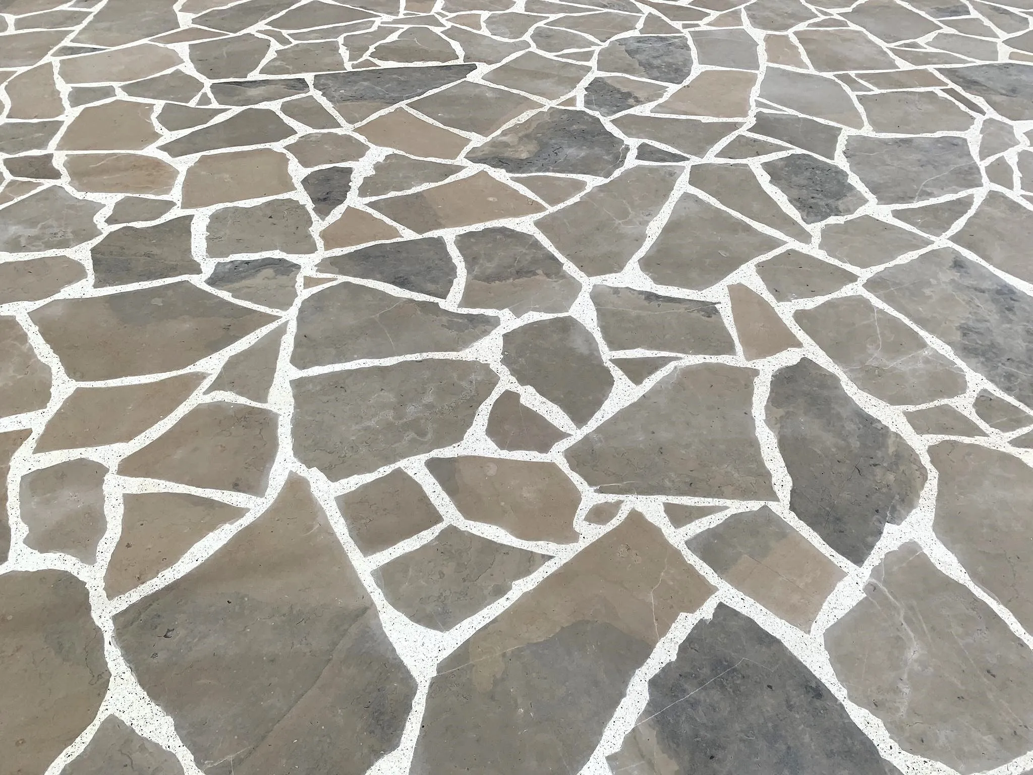 terrazzo palladiano com pedras de grande dimensão e juntas preenchidas com terrazzo, para revestimento de pavimento em terraço exterior. / palladian terrazzo with large stones and joints filled with terrazzo, in a outdoor terrace floor.
