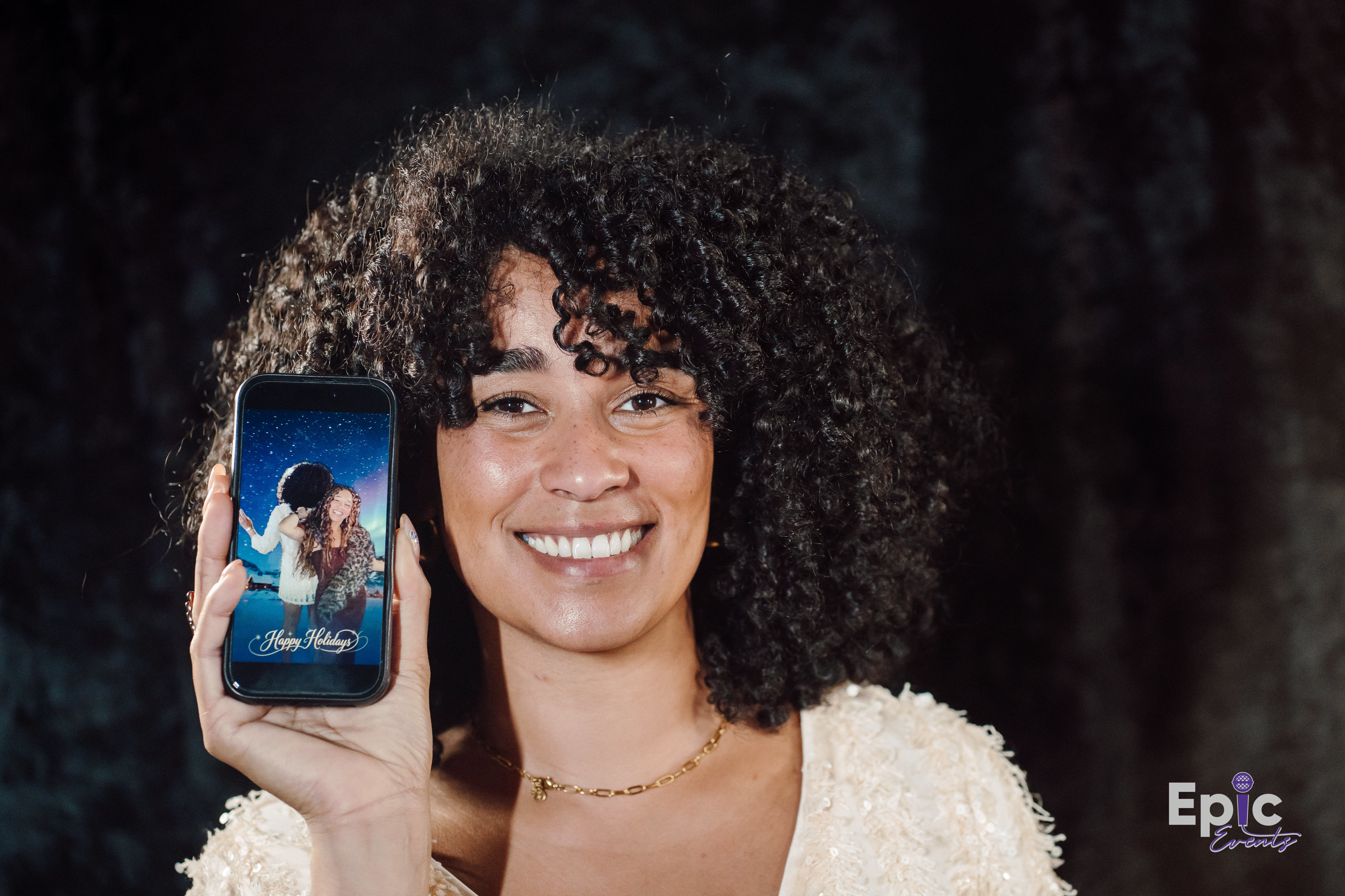 Guest holding her Holiday Constellation
northern-lights photo portrait at a holiday event in
the DMV