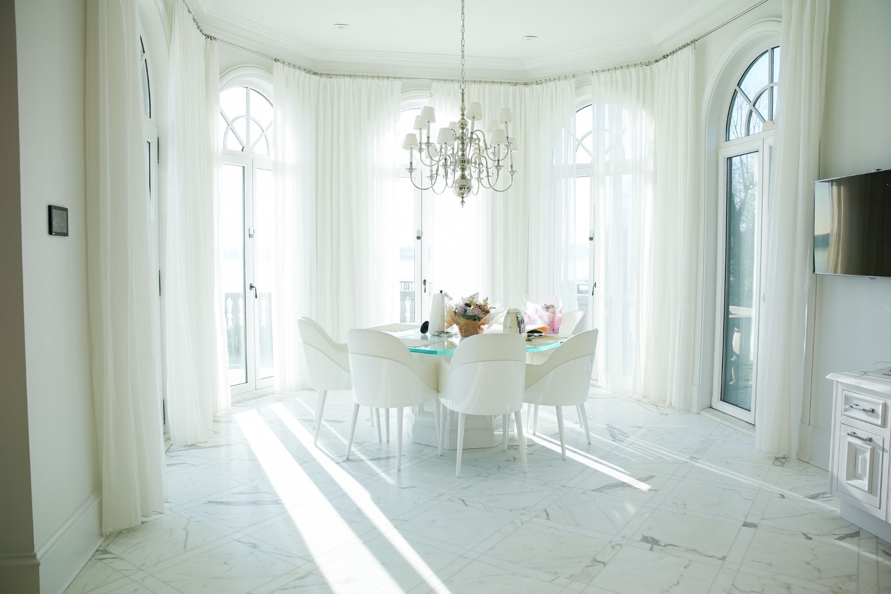 Sunlight streaming across polished marble flooring inside a luxury dining room
