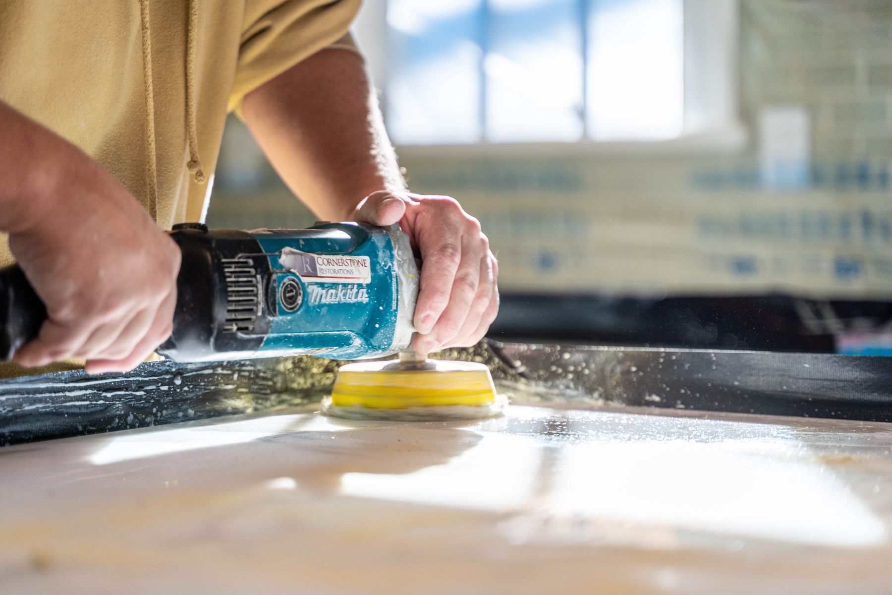 Cornerstone Restoration technician professionally polishing a natural stone surface