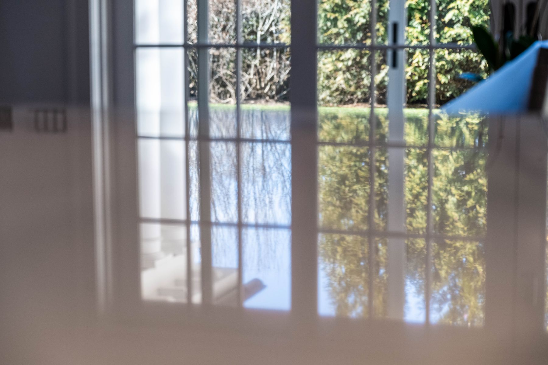 Reflection of windows and outdoor greenery across a professionally polished natural stone surface