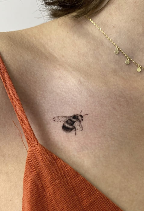 Tatuaje de una abeja pequeña en el pecho