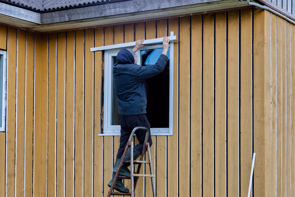 Professional contractor inspecting wood siding on a house for hidden rot