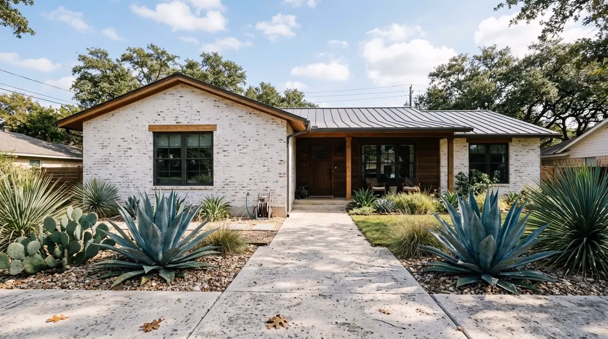 Beautiful modern farmhouse exterior featuring a breathable white limewash brick finish and native landscaping