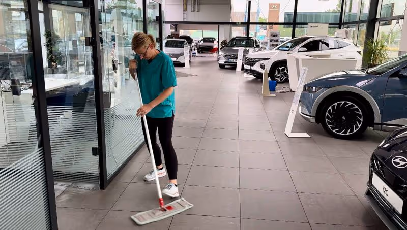 Mitarbeiterin von Lieven Services bei der Unterhaltsreinigung und Büroreinigung eines Gebäudes: Gründliche und professionelle Büroreinigung.