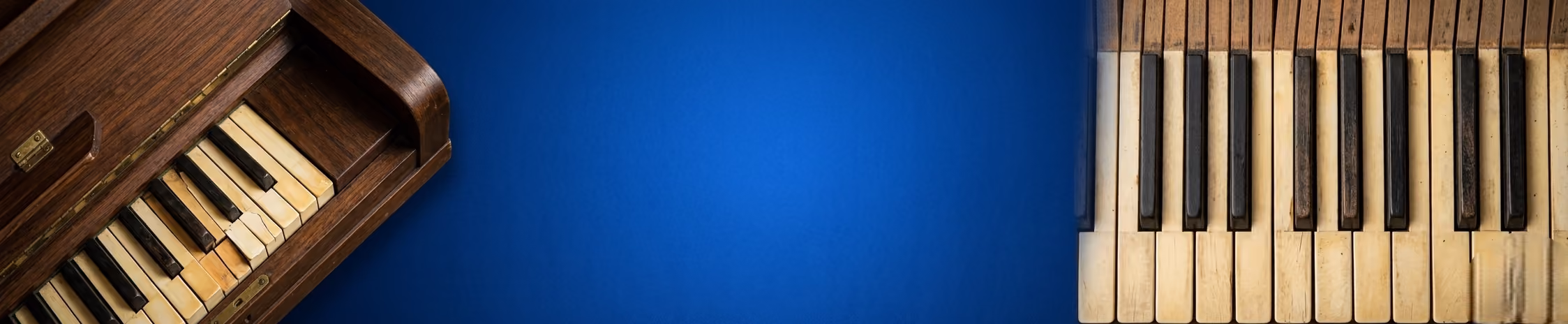Two antique piano keyboards on blue background