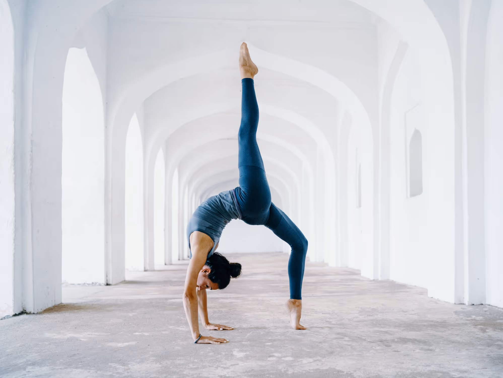Woman doing yoga in old white building