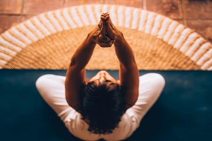 A woman doing yoga with her hands up to the sky
