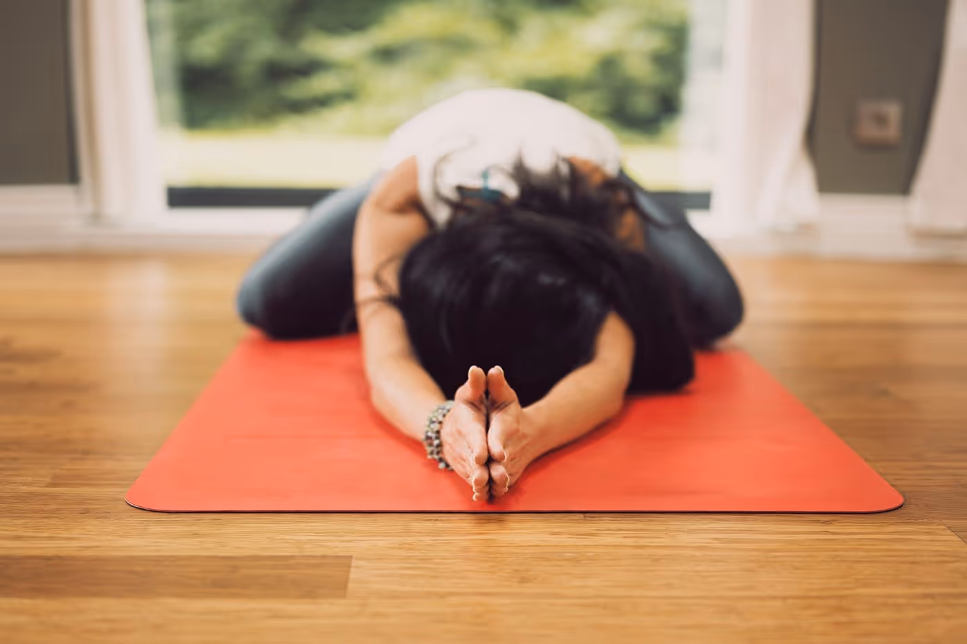 A woman doing a form of Yin Yoga on a mat.