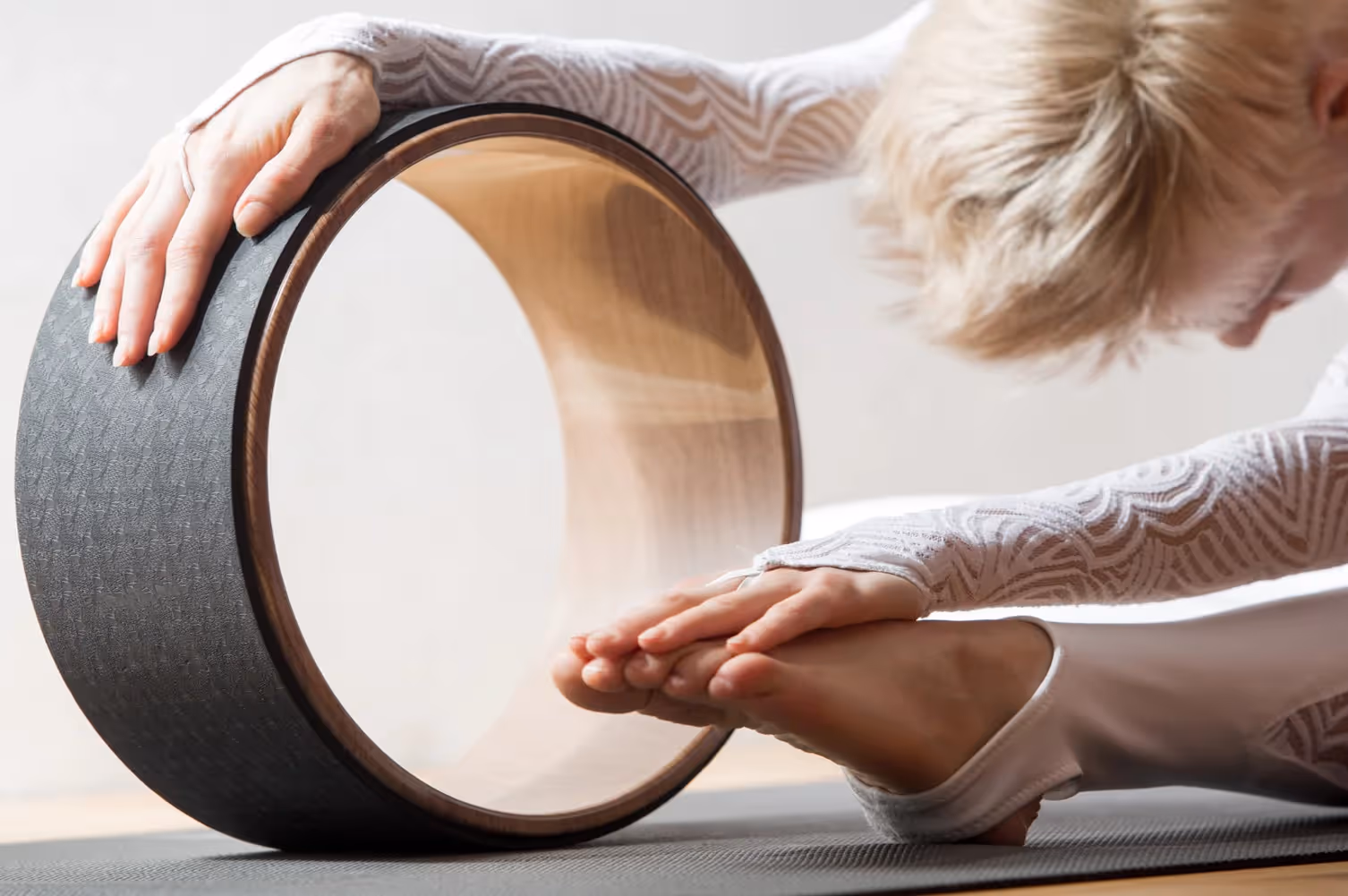 A woman doing yoga with a yoga wheel
