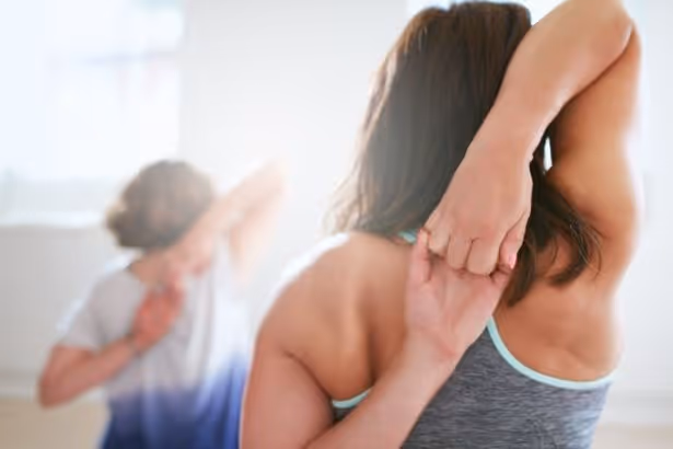 Two female yogis practicing for shoulder mobility