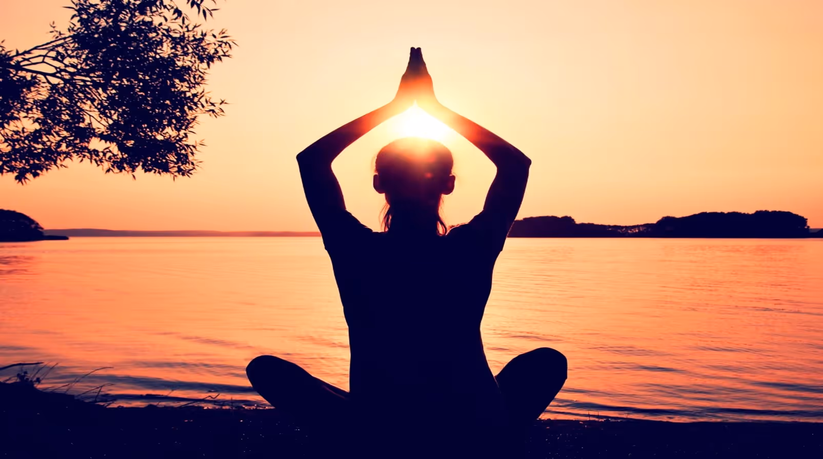 Yogi lady practicing yoga in front of the sea at sunset