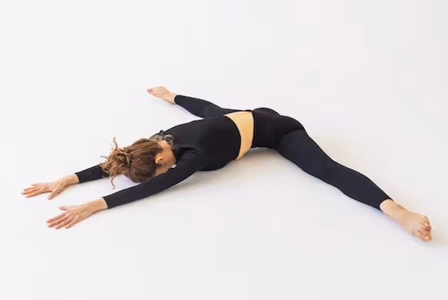 A young woman in black sportswear practicing yoga performs a samokanasana exercise