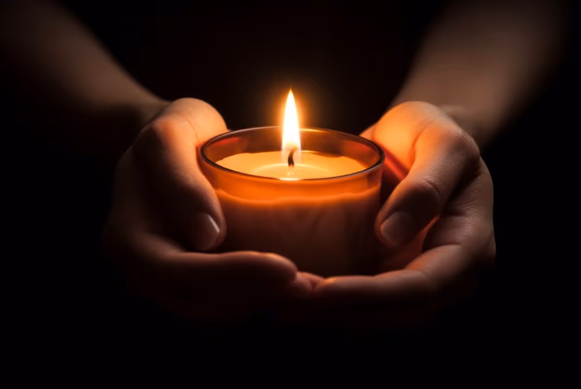 Bright candle on two hands