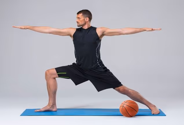 Male basketball player doing yoga on a blue mat with a basketball