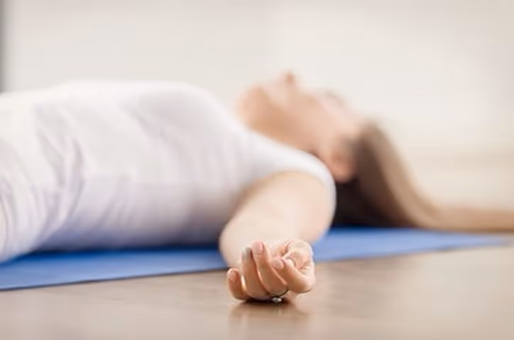 The yogi lady is lying on the mat.