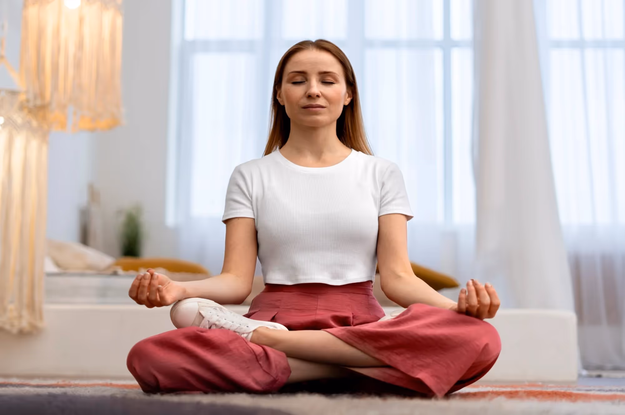 A woman sitting in lotus position and meditating.