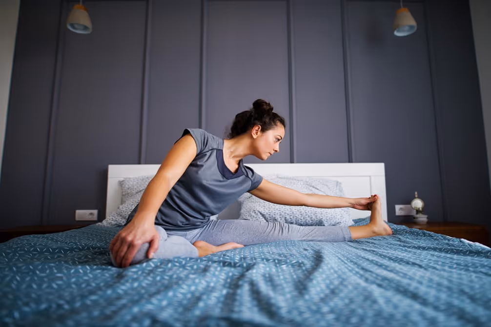 Woman doing yoga in bed