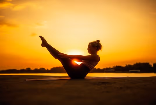 A woman doing yoga at sunset