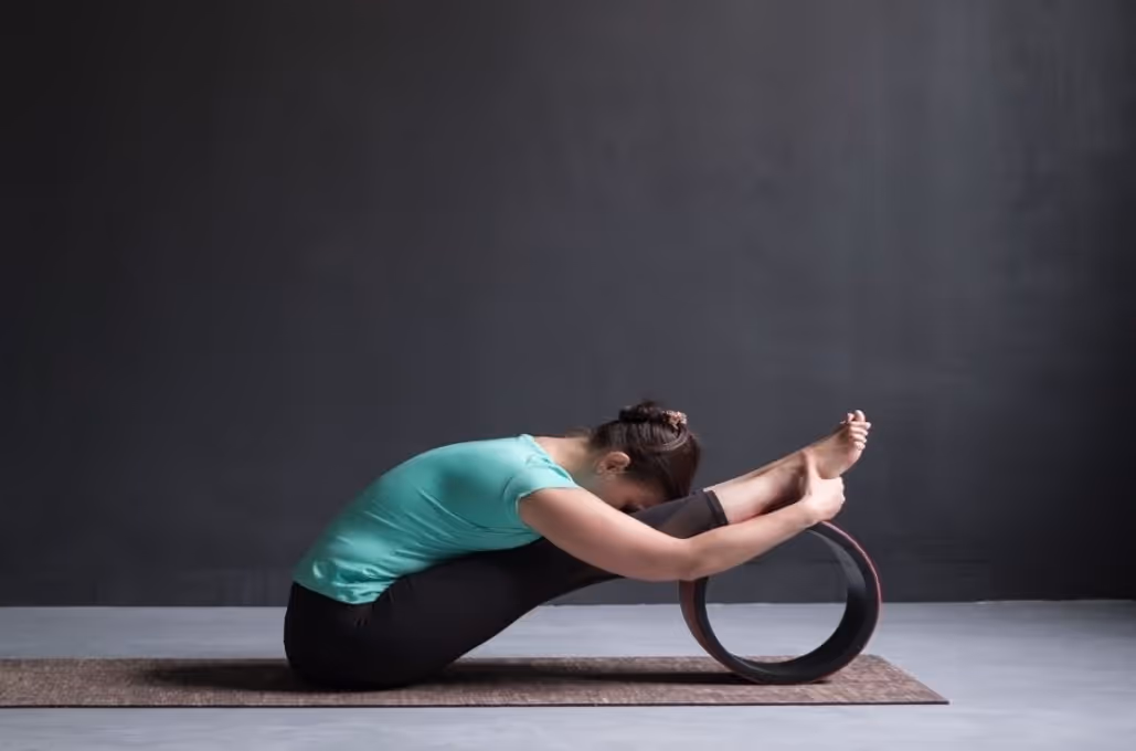 Yogi lady doing asana pose with yoga wheel