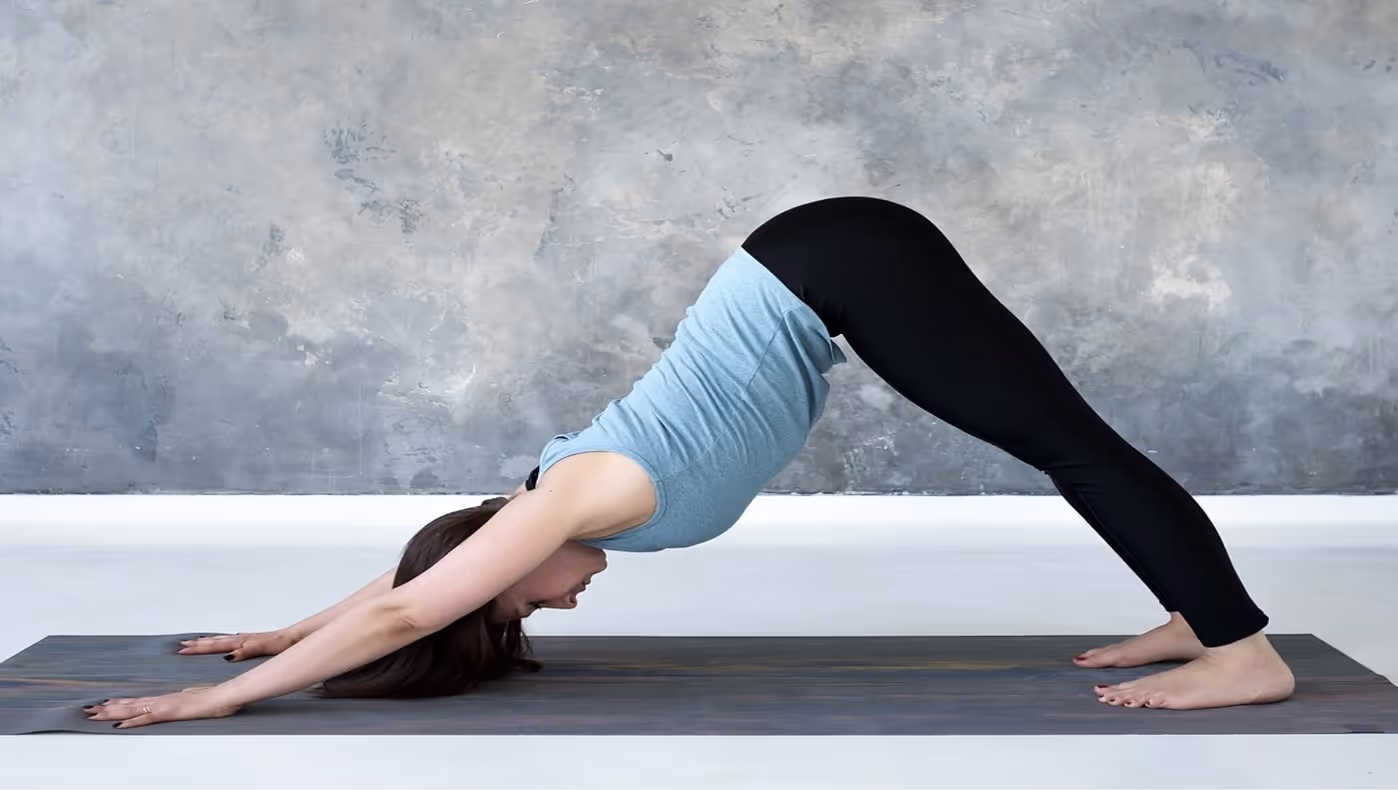 Yogi lady doing downward dog on the mat