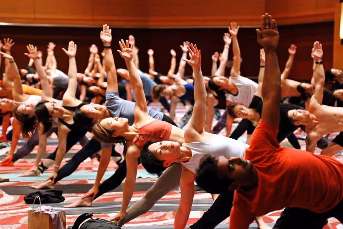 Yogi men and women doing asanas in yoga class