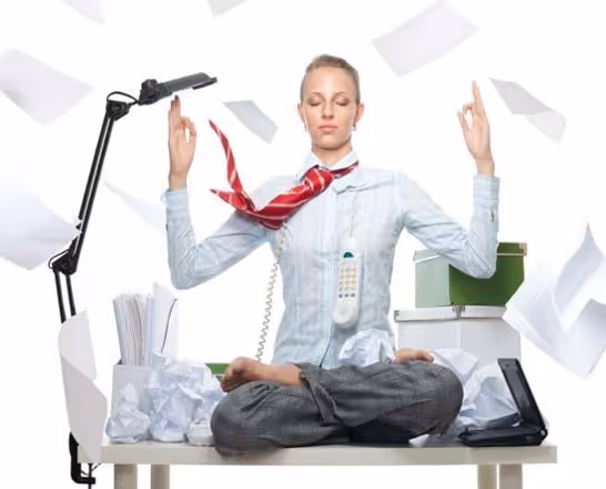 A woman in a uniform at work sitting at a desk in the lotus position