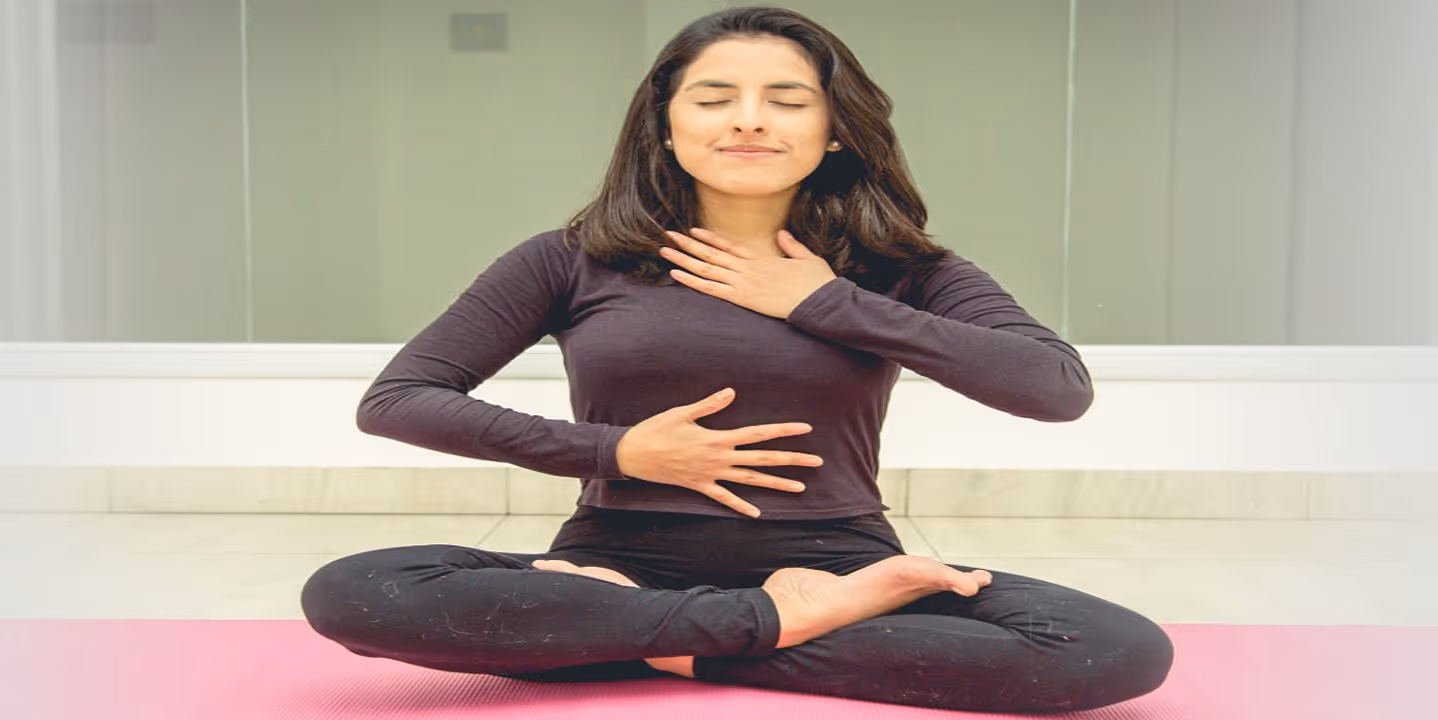 The yogi lady, in the lotus position, placed one hand on her throat and the other on her stomach.