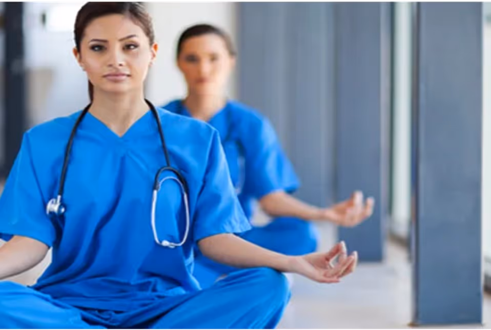 Two female doctors in blue uniforms in lotus position and meditation