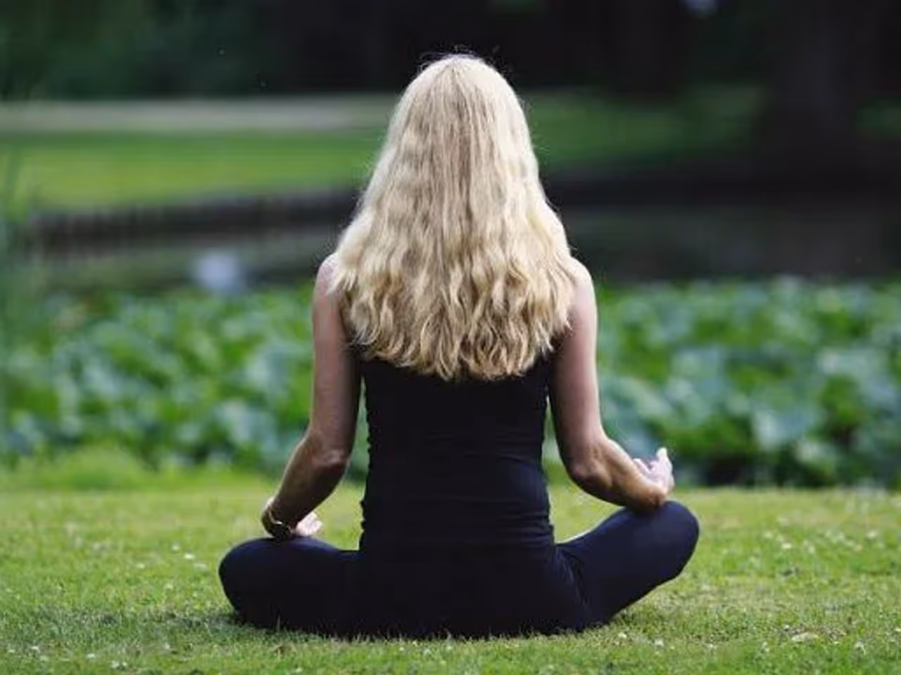 Young gay woman with blonde hair in lotus position