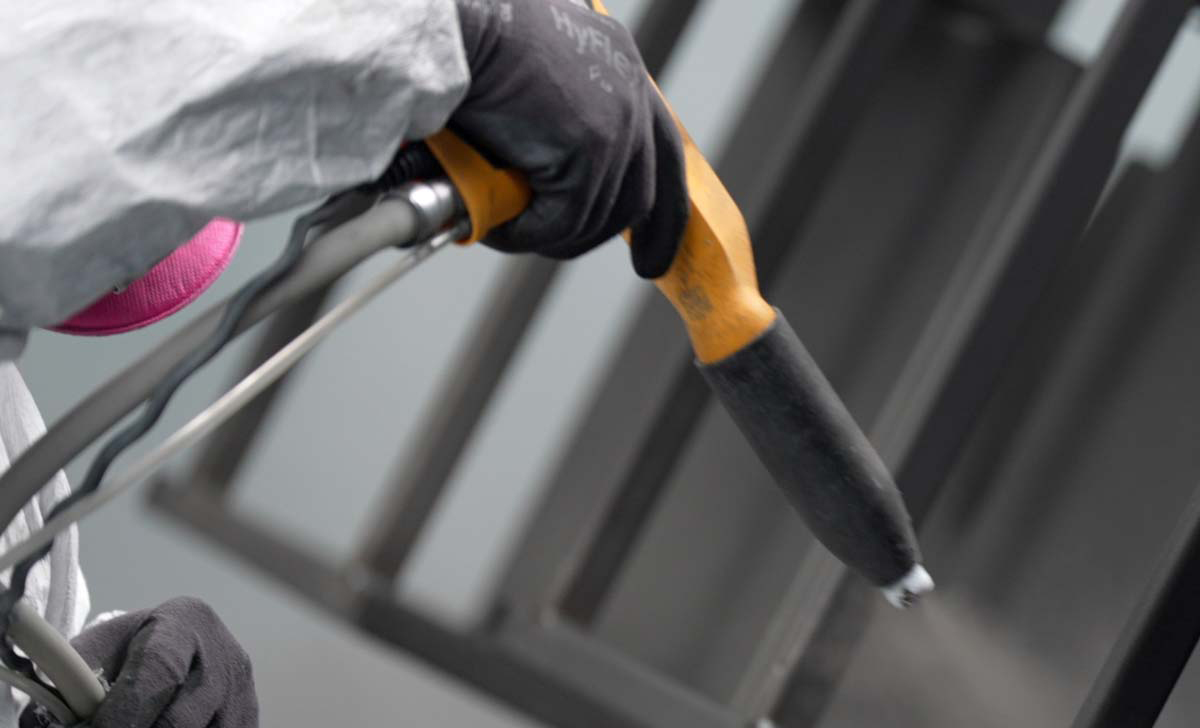 A GC Metal painter applying a powder coating