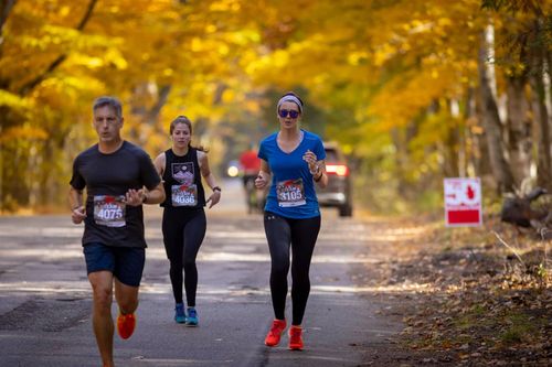 Runners running through fall backdrop in door county wisconsin