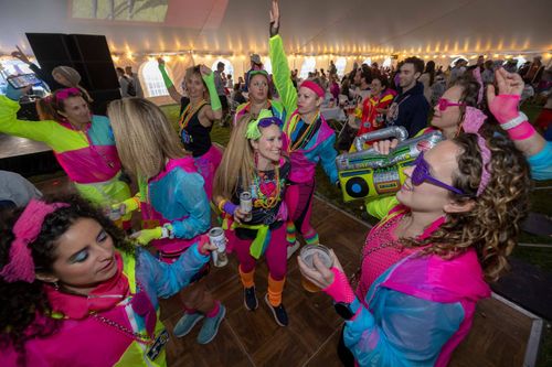 a group of people dancing at the after party celebration