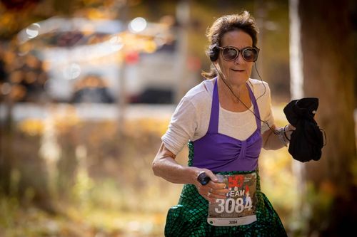 a female runner running with a fall backdrop