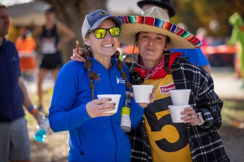two women pose for a picture at a race